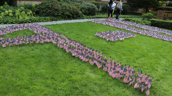 Small flags arranged into 9-11 on the grass.