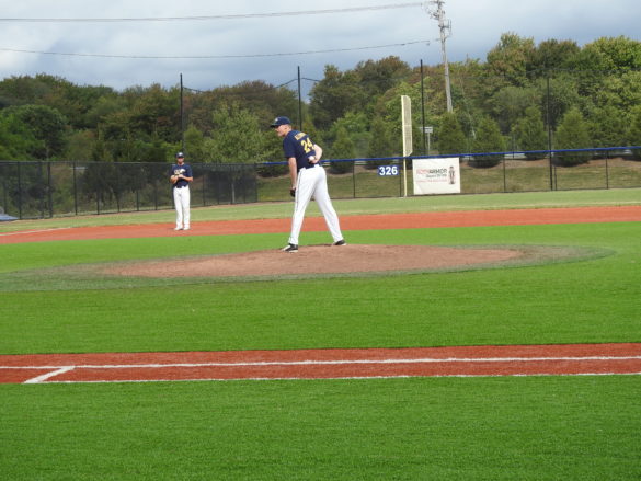 SJC alumni pitcher standing on the baseball field.