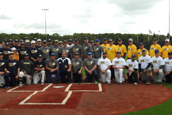 SJC baseball alumni posing on the field.