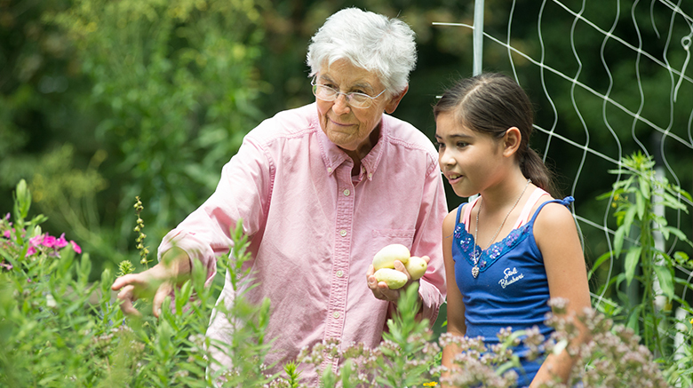 S. Mary Lou Buser points out different vegetables to a girl.