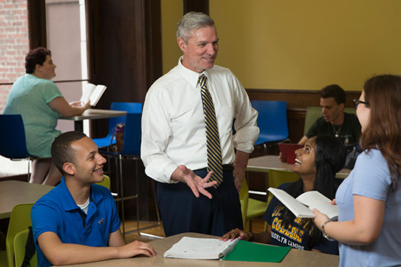 Administrator and college students talking.