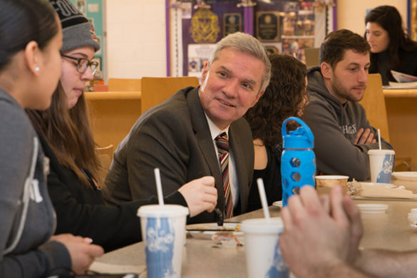 Students and administrator talking at table.