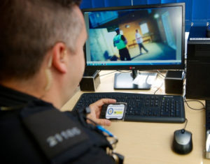 Police officer watching footage from a body-worn camera.