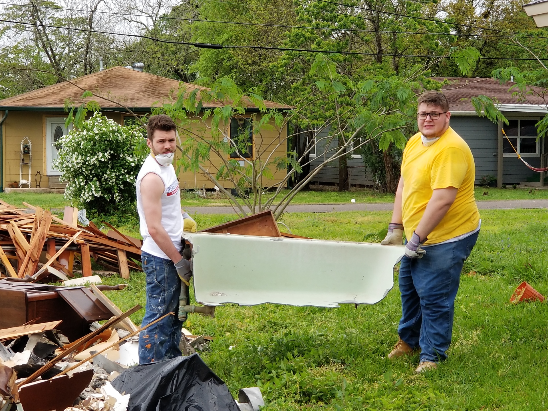 SJC Brooklyn students Nick Gangone and Sean Devine Dunn holding the tub they removed from Ruth's home. 