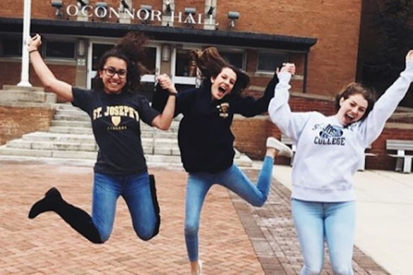Students jumping for joy at College.