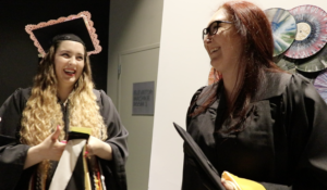 Two women in caps and gowns for graduation.