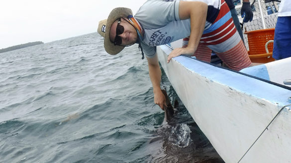 Alex Pushnick holding a shark's fin in Belize.