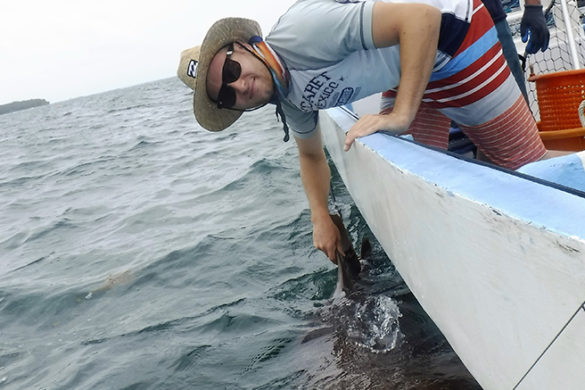 Alex Pushnick holding a shark's fin in Belize.