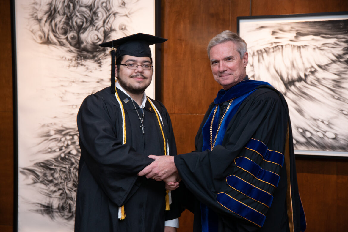 Dr. Boomgaarden shaking the hand of a scholarship recipient.