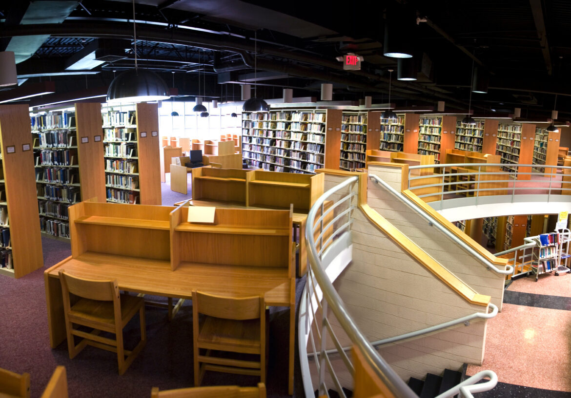 The upper level has rows and rows of books and desks for students to sit down at and study or work.