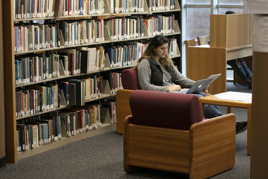 Student studying in SJC Long Island's Callahan Library before finals.