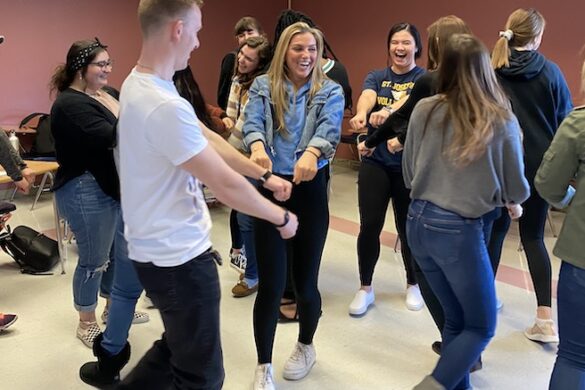 Students laughing and moving about the classroom.