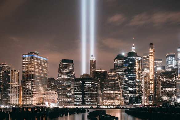 A night view of New York City, with two lazer lights where the twin towers used to sit.