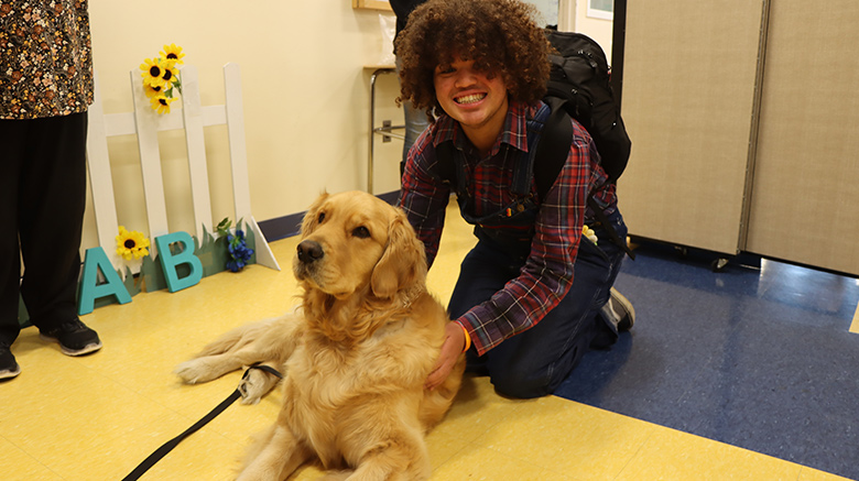 Student petting dog before finals.