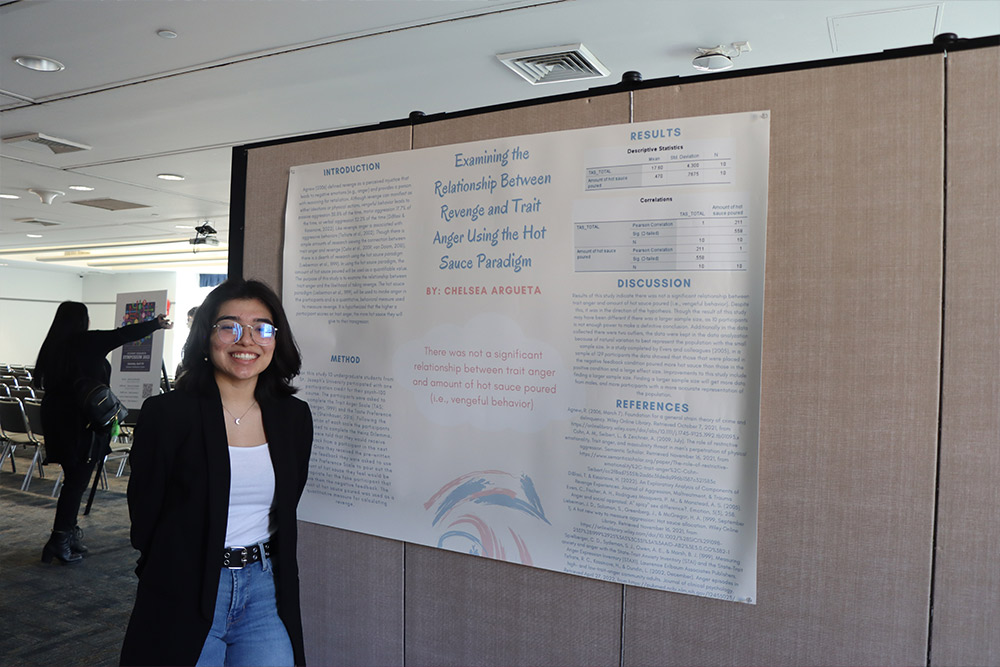 Student with her poster at the Student Research Symposium.