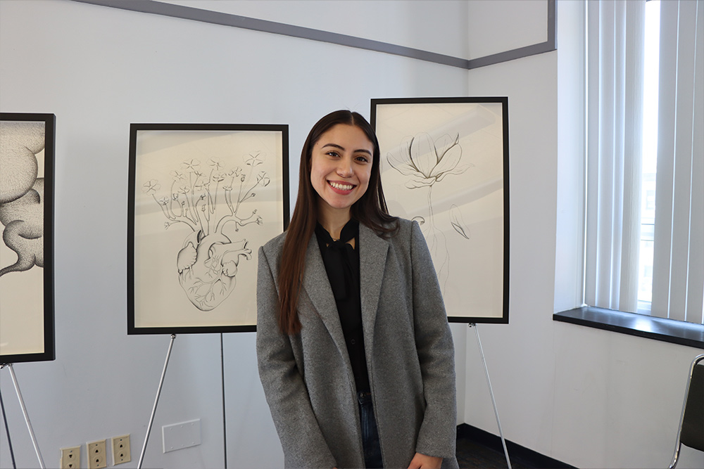 Student with artwork at the Student Research Symposium.