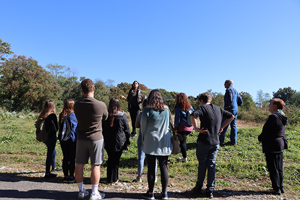 Mission Day attendees stand in front of the industrial-sized, constructed wetland.