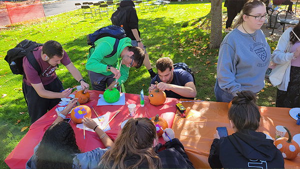 Students painting pumpkins at the Fall Fest Carnival.