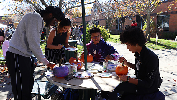 Students painting pumpkins at the Fall Fest Carnival.