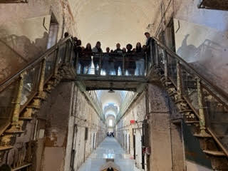 students in prison museum on stairs.
