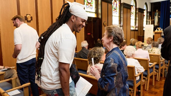 Mass attendees smiling and speaking with one another.