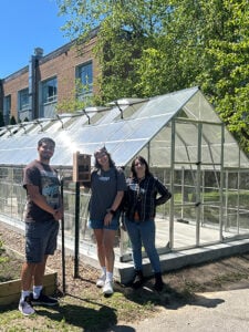 Students standing in front of a greenhouse.