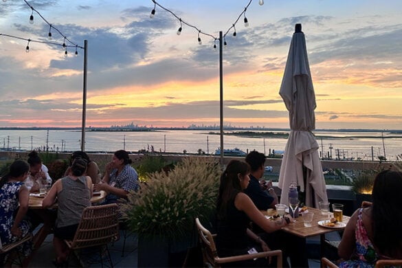 Guests enjoying dinner outdoors during sunset.