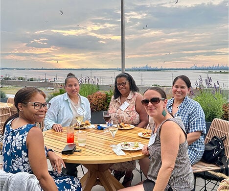 A group of guests smiling for the camera on the outdoor terrace.
